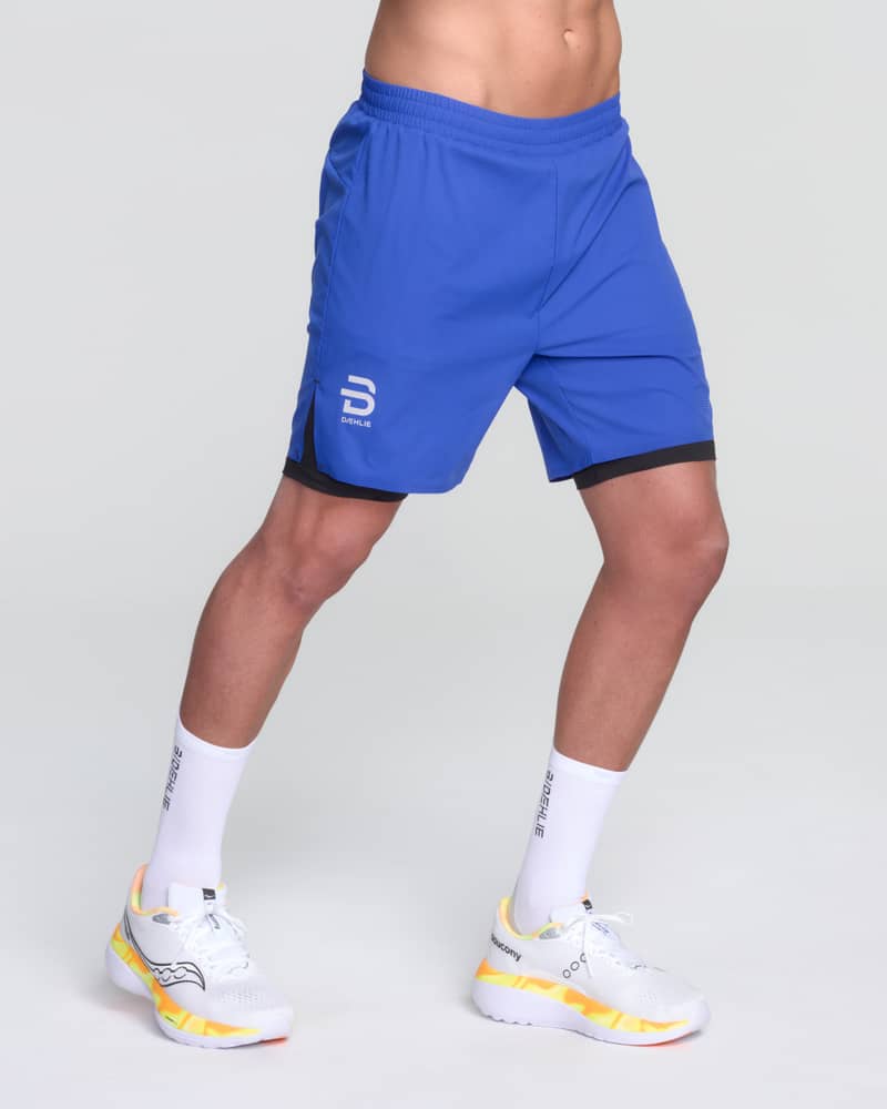 Runner showing the front of Dæhlie's blue Shorts Run 365, designed for maximum mobility during a run.