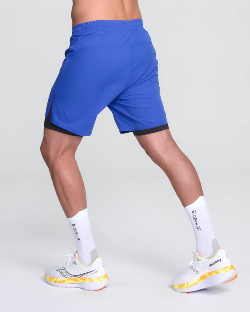 Runner's back side view in Dæhlie's blue Run 365 shorts, demonstrating the shorts' performance for daily miles.