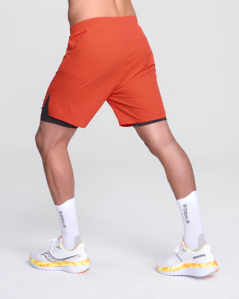 Back side view of a runner in Dæhlie's red Run 365 shorts, highlighting the lightweight design in motion.