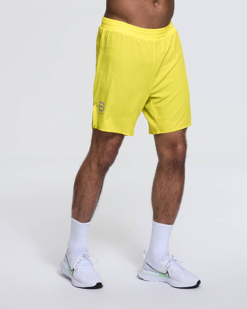 Runner wearing Dæhlie's bright yellow Shorts Run 365, highlighting their lightweight, active fit.