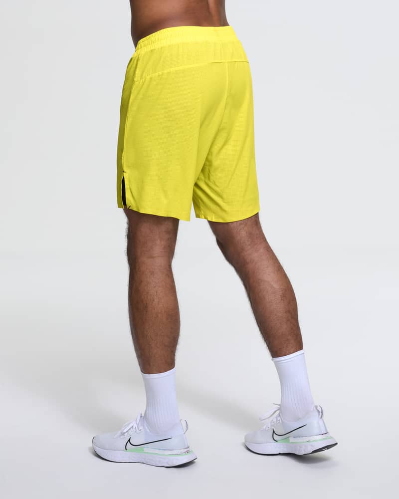 Back view of a runner in Dæhlie's yellow Run 365 Shorts, showing reflective details for visibility.