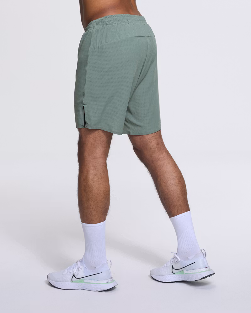 Runner's back side view in Dæhlie's green shorts, demonstrating freedom of movement for runners.