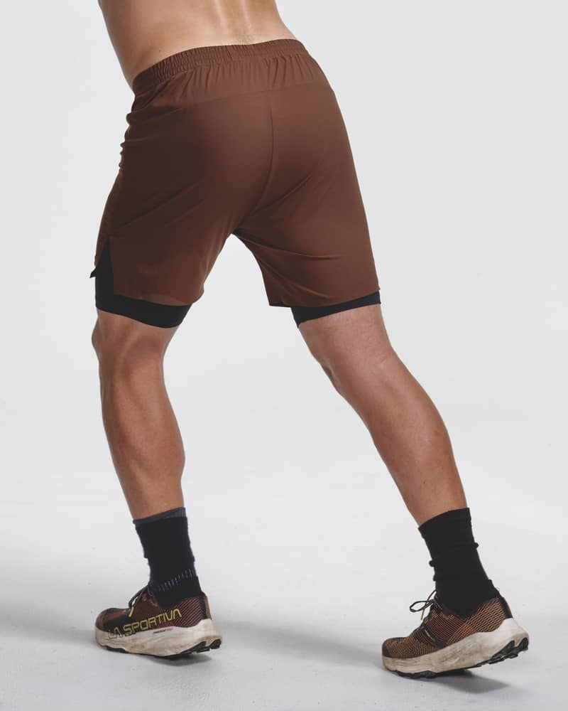 Back view of a male runner in Dæhlie's brown shorts, showing the shorts in motion during a trail run.