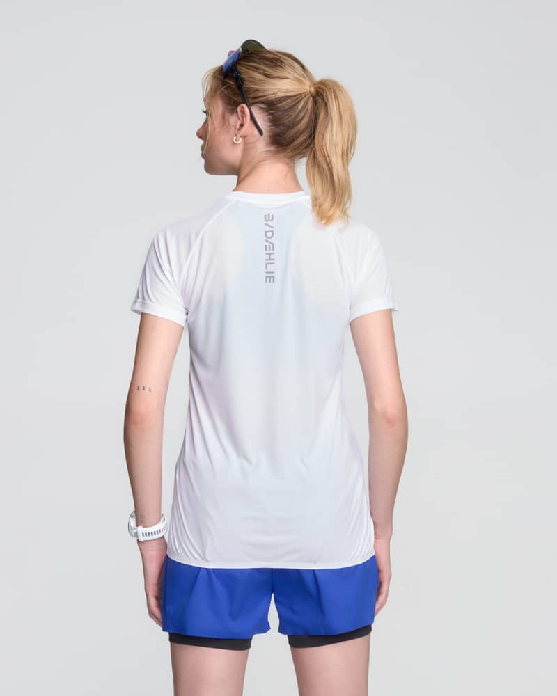 Back view of a woman wearing the white and blue Dæhlie Run 365 t-shirt, showing the regular fit design.