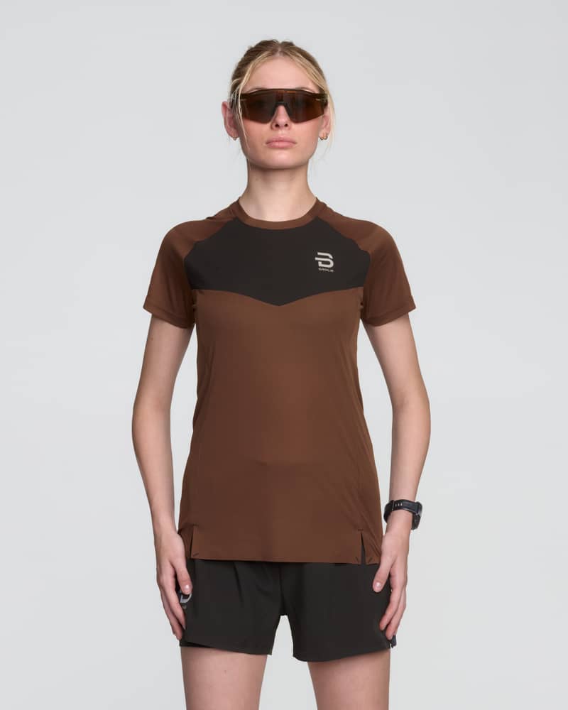 Female runner wearing the brown and black Dæhlie Run 365 t-shirt for high-intensity running and racing.