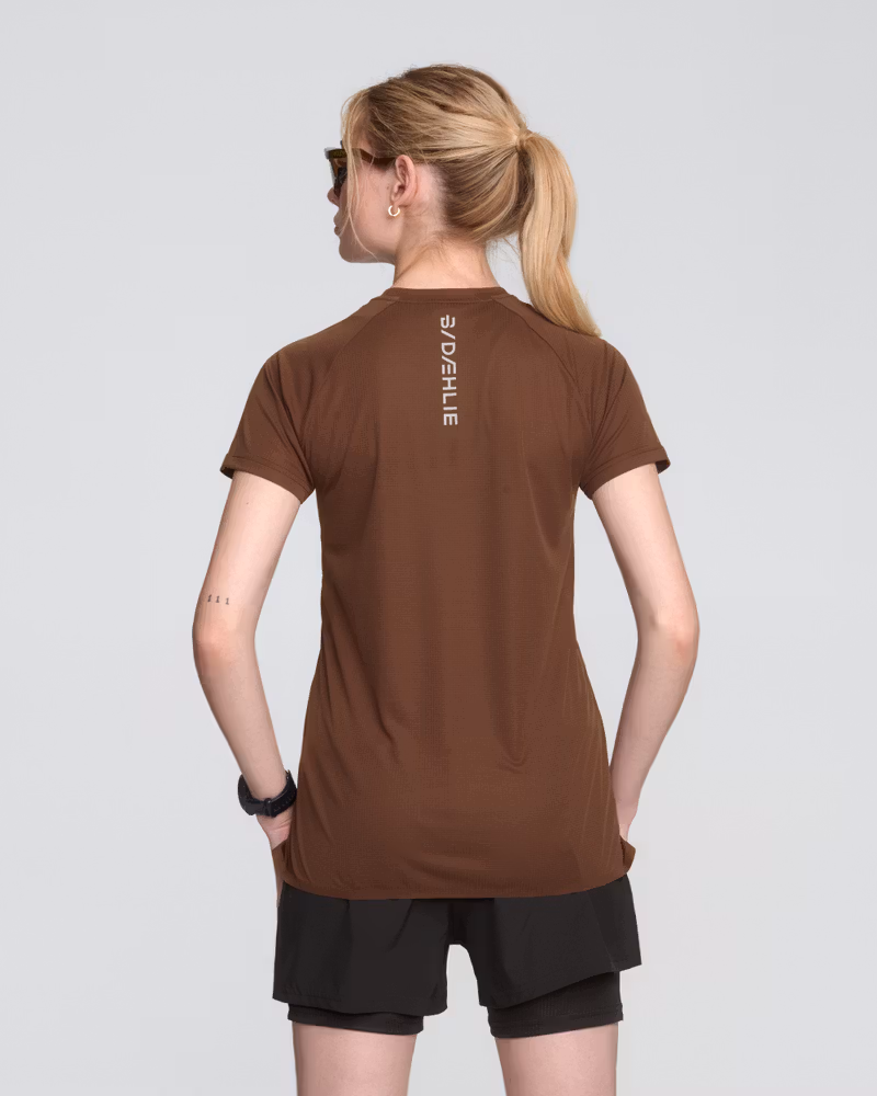 Rear view of a woman in the brown Dæhlie Run 365 t-shirt, emphasizing its moisture-wicking properties.