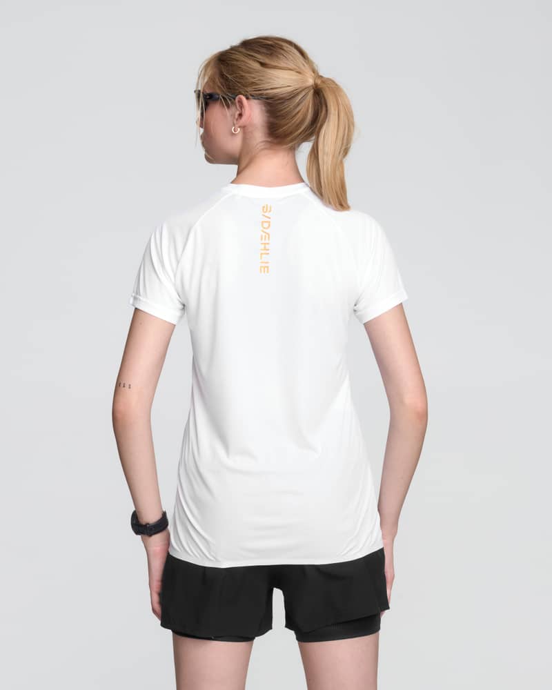 Back view of a woman wearing the white and black Dæhlie Run 365 t-shirt, showing the athletic fit and design.