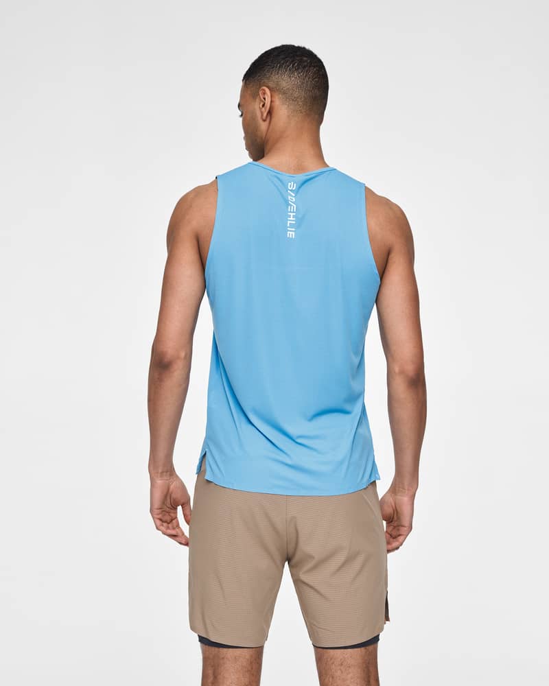 Rear view of a runner in a light blue Dæhlie Singlet Run 365, designed for high-pace summer training.