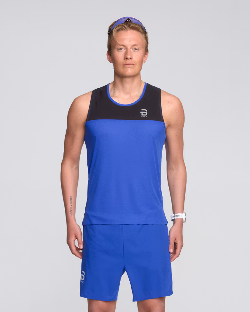 Man wearing the royal blue Dæhlie Singlet Run 365, a versatile piece for everyday training and race conditions.