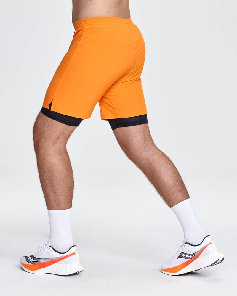 Back view of a runner in Dæhlie's orange shorts, showing the comfortable fit for jogging.