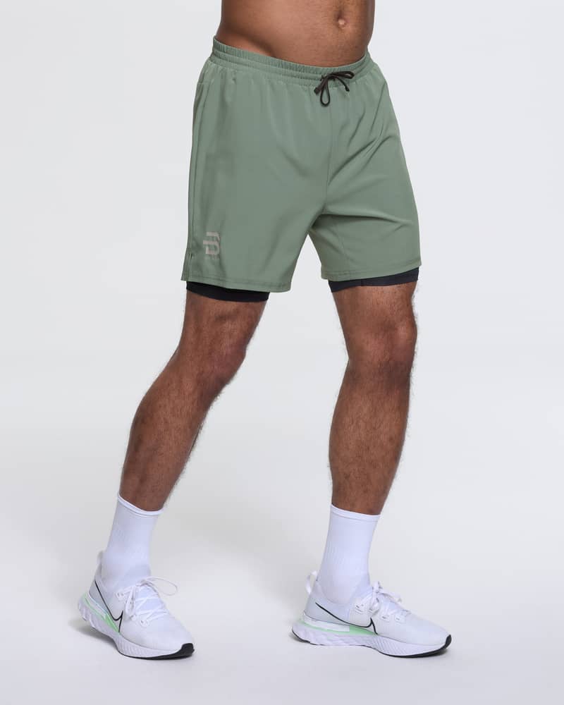 Runner wearing Dæhlie's green Shorts Run 2 in 1, designed for comfort on mild weather runs.