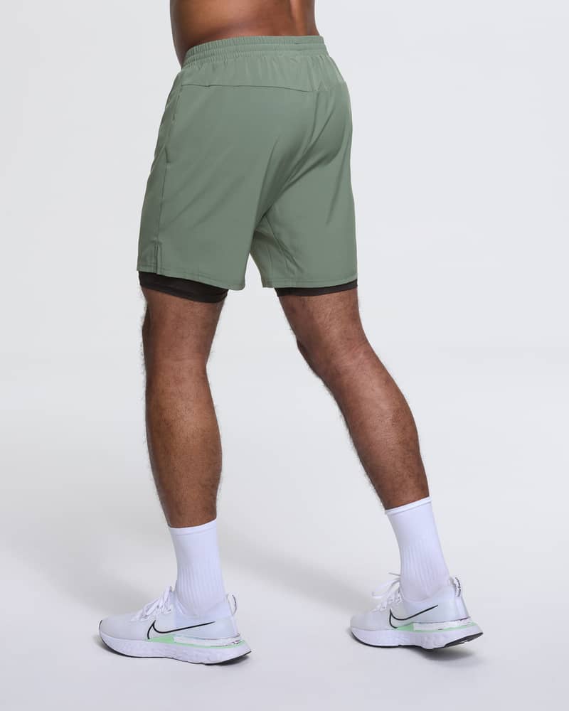 Back view of a runner in Dæhlie's green 2-in-1 shorts, showing the active, regular fit.