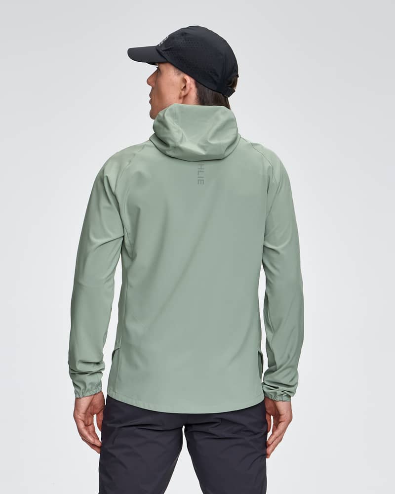 Back view of a male model wearing the light green Dæhlie Jacket Run 2.0, showing its regular fit and hood.