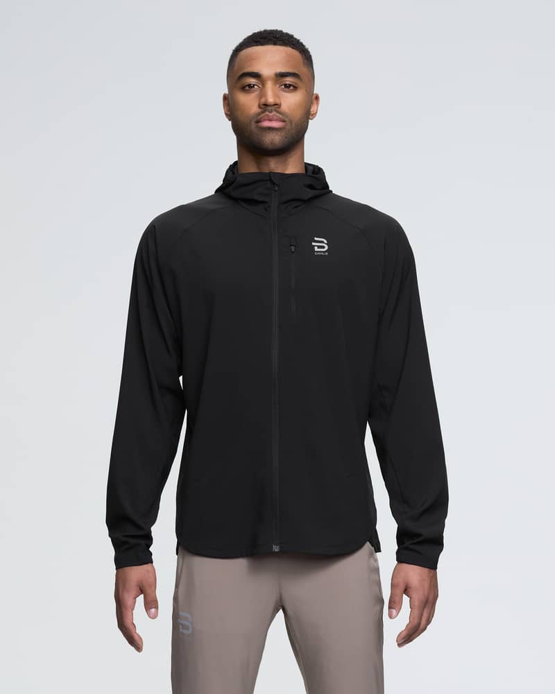 Runner in the black Dæhlie Jacket Run 2.0 for men, with reflective details for visibility during evening runs.