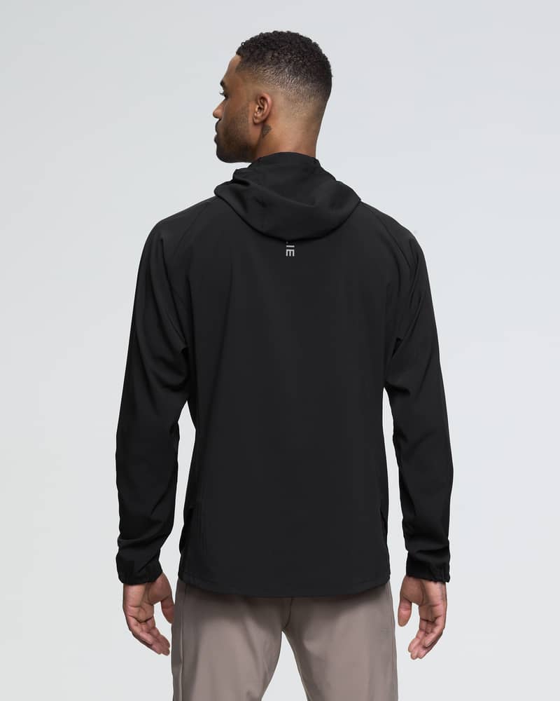 Back of a male runner wearing the black Dæhlie Jacket Run 2.0 for all-weather running protection.