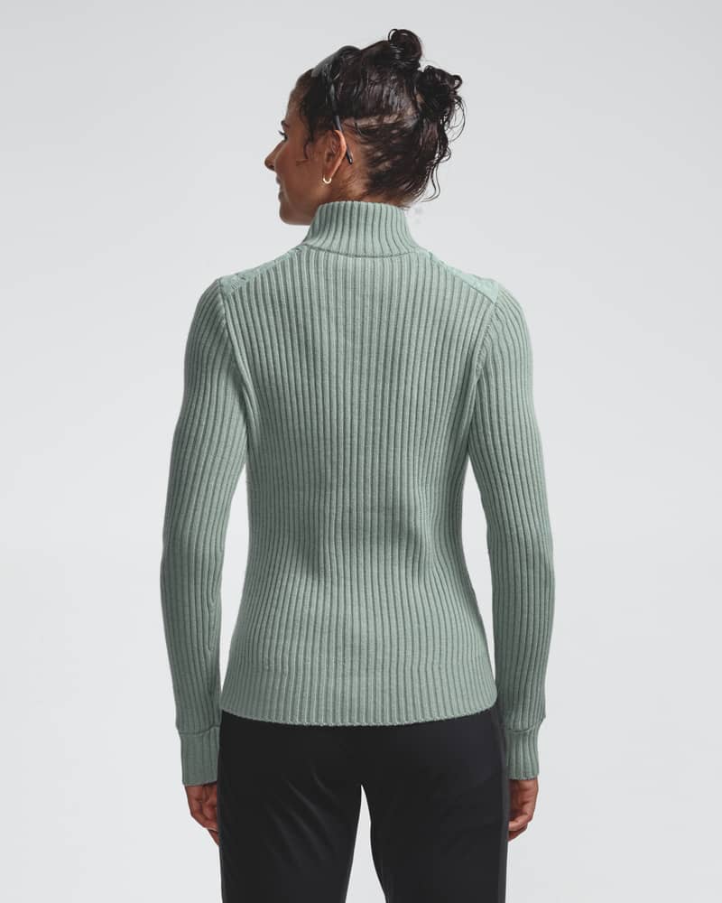 Back view of a woman in the light green Half Zip Comfy 2.0 sweater, highlighting the merino wool blend and fit.