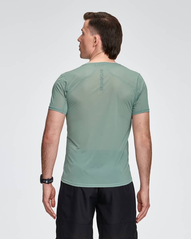 Back view of a runner in the light green Dæhlie T-Shirt Air, with a focus on the breathable back panel design.