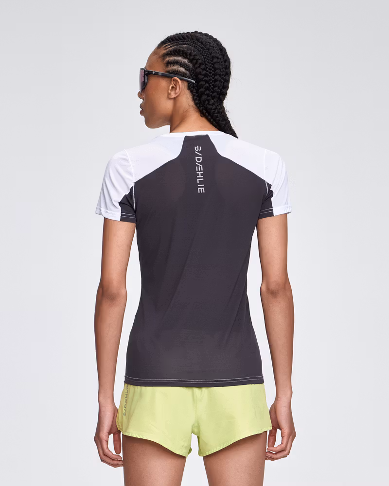 Back view of a woman wearing the black and white Dæhlie T-Shirt Air, emphasizing the strategically placed mesh panels.