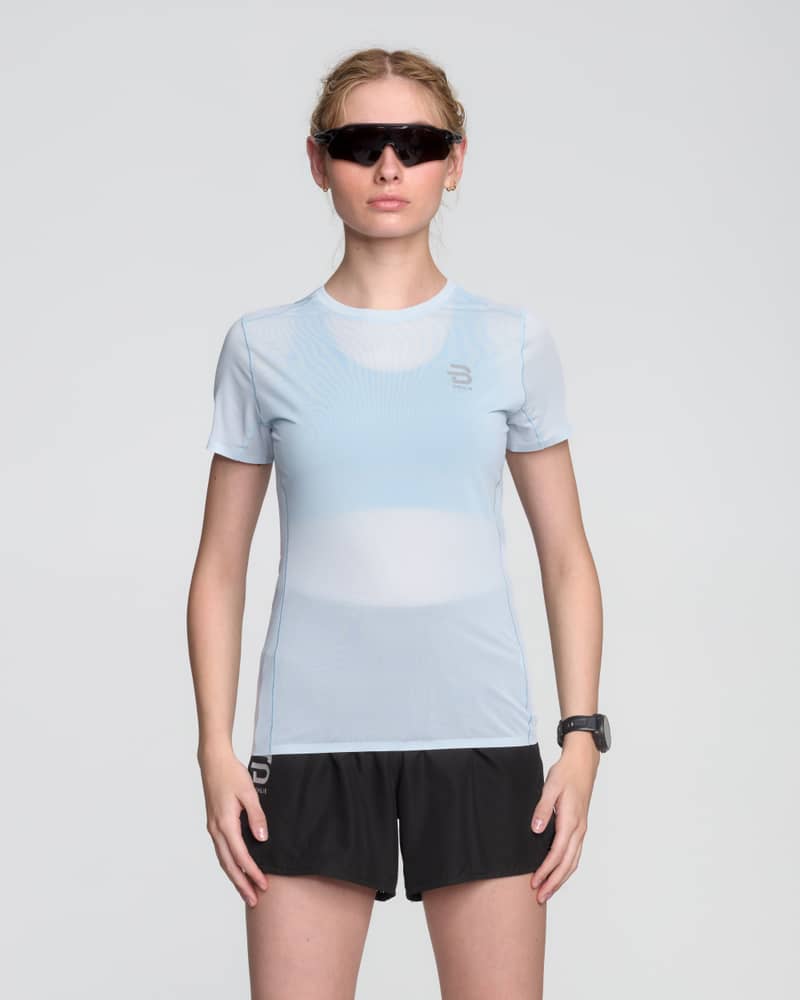 Female runner wearing the light blue Dæhlie T-Shirt Air, designed for a comfortable and flattering regular fit.