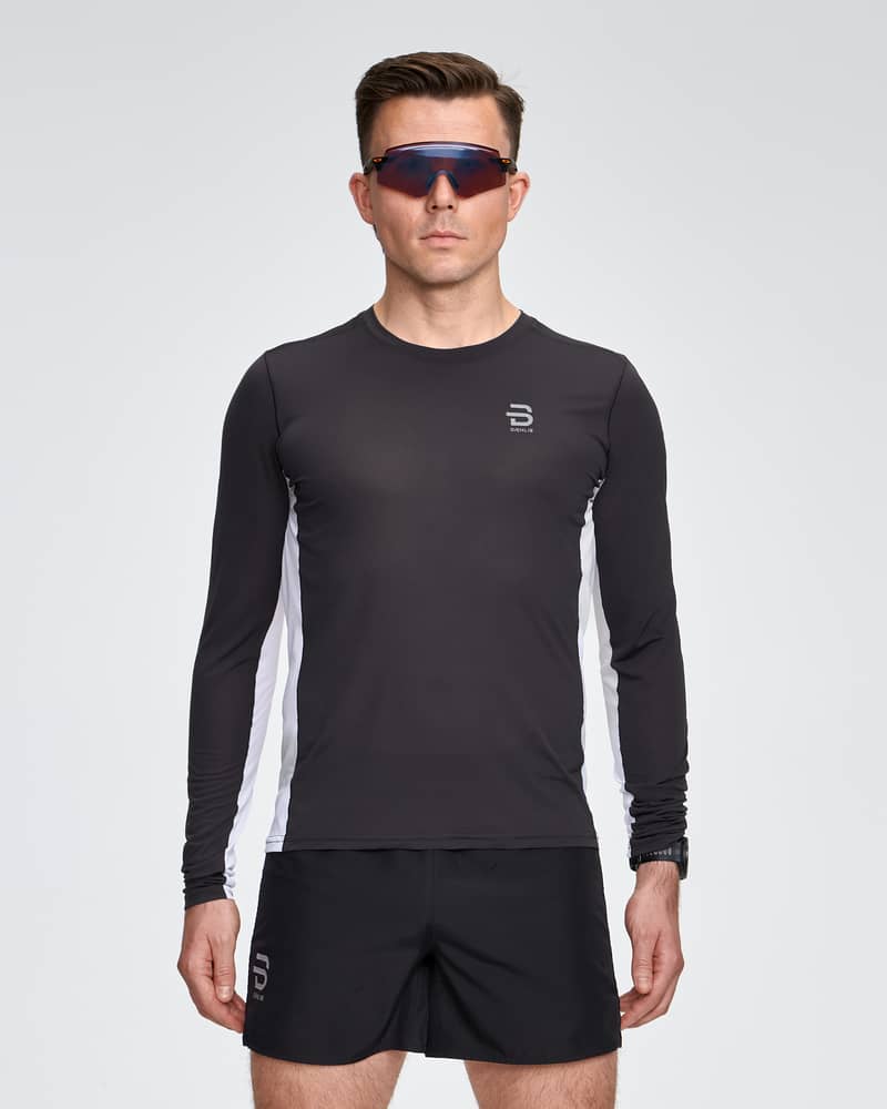 Man running in the white and black Dæhlie Long Sleeve Air, a long-sleeve training shirt engineered to feel like a second skin.