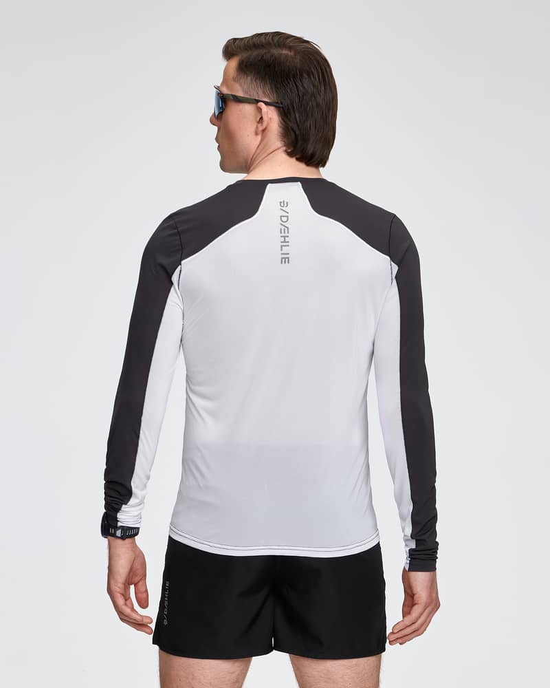 Back view of a man in the white and black Dæhlie Long Sleeve Air, emphasizing the shirt's thermoregulating features.