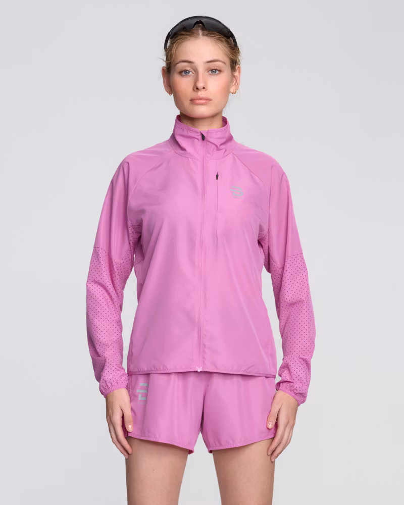 Female runner in the pink Dæhlie Jacket Air, a vibrant and lightweight jacket for warm weather workouts.