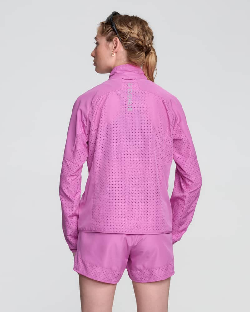 Back view of a woman in the pink Dæhlie Jacket Air, showcasing its breathable design for staying cool.