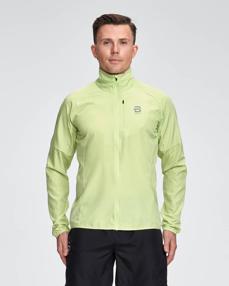 Man in a light green Dæhlie Jacket Air, a breathable and water-repellent jacket perfect for running.