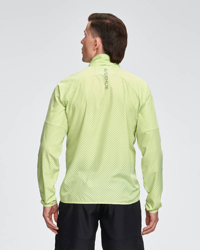 Back of a man wearing the light green Dæhlie Jacket Air, highlighting its lightweight design for intense workouts.