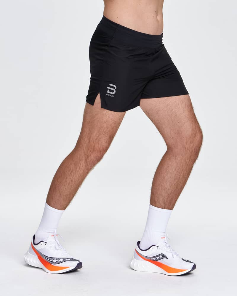 Male runner models the Dæhlie black Shorts Air 5 Inch, perfect for high-performance running in warm conditions.
