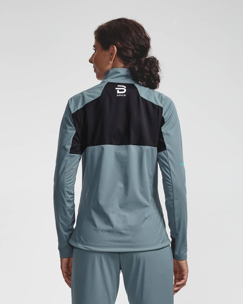 Back of a woman wearing the two-tone teal Jacket Challenge 3.0 for an active skier.