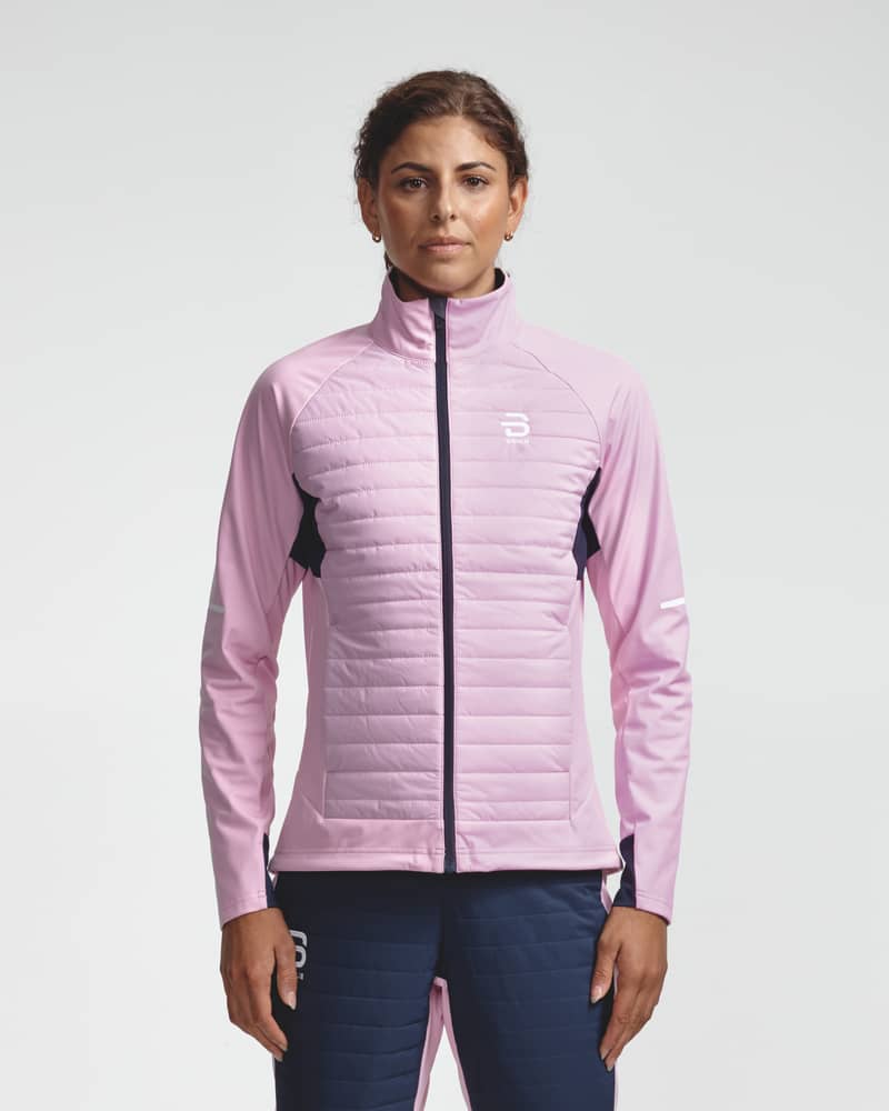 Front view of a woman in the light pink and navy Jacket Challenge 3.0 for nordic skiing.
