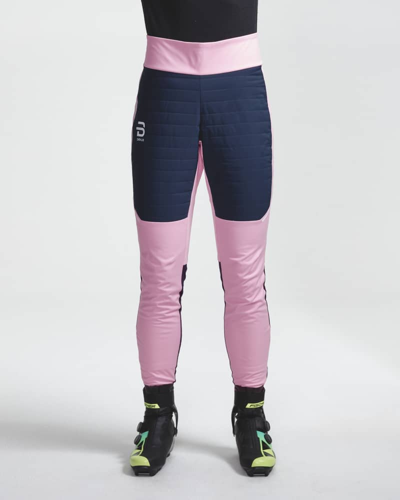 Woman facing forward in pink and navy Challenge 3.0 ski pants, showing the color-block design and thermal thigh padding.