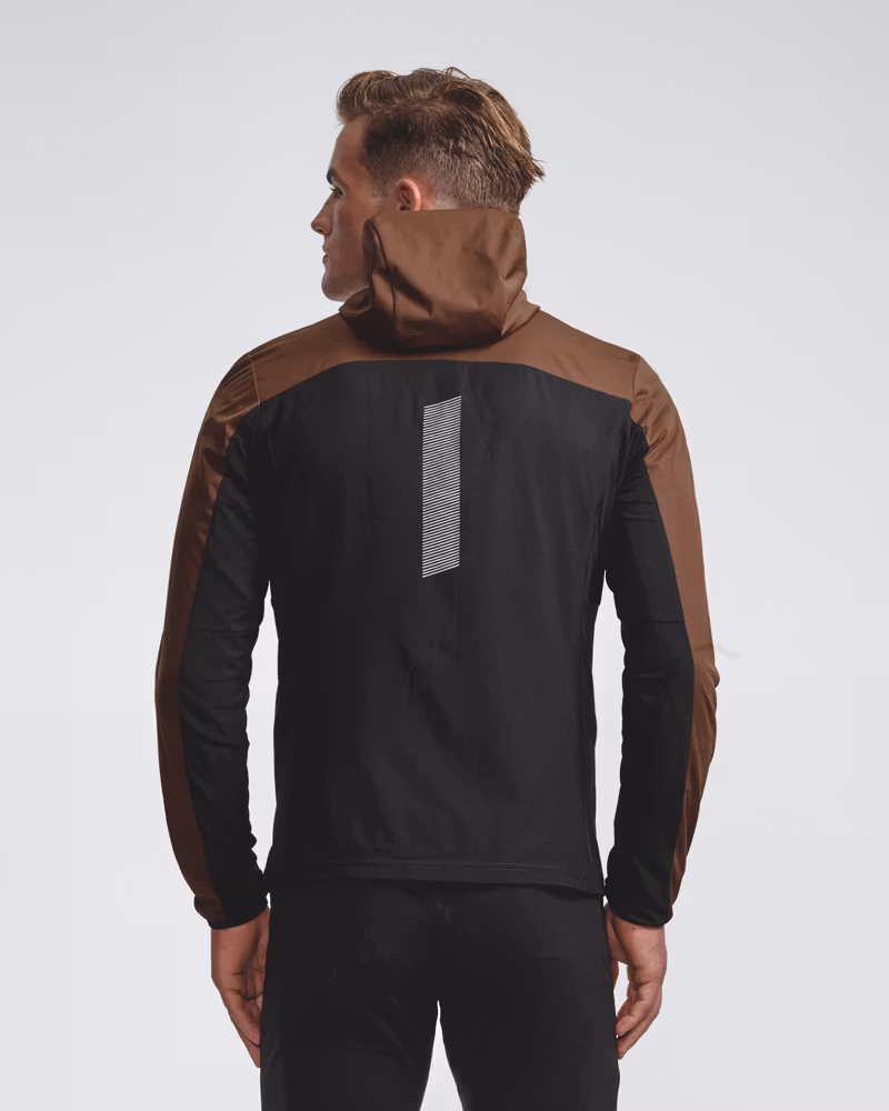Rear view of a model in the brown Jacket Winter Run Protect, featuring the black back panel and a vertical reflective stripe for safety.