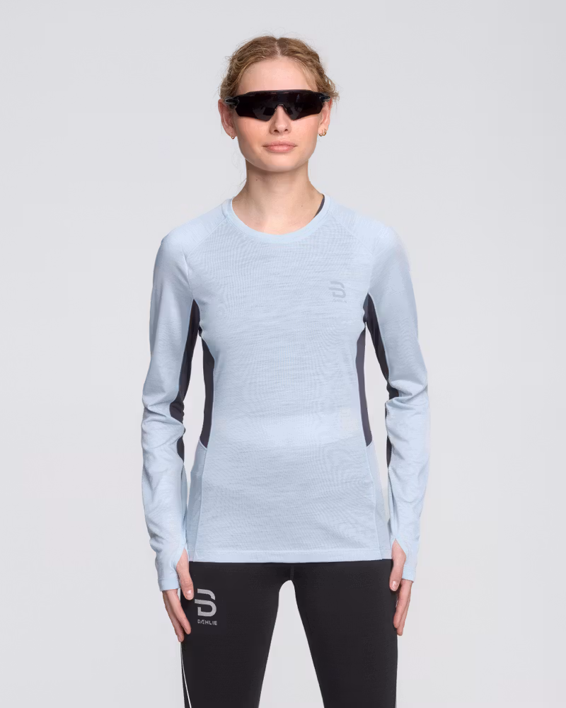 Woman wearing the light blue Dæhlie Long Sleeve Tech Wool, a base layer made with non-mulesing merino wool.