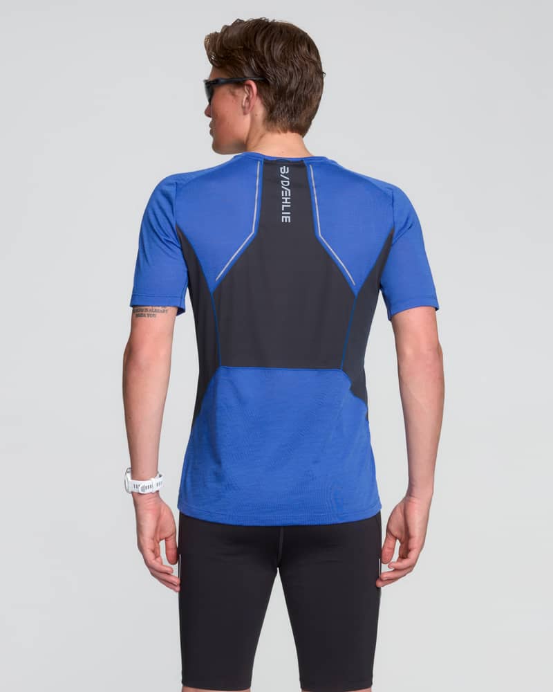 Back view of a runner wearing the blue Dæhlie T-Shirt Tech Wool for men, showing the breathable ventilation panel.