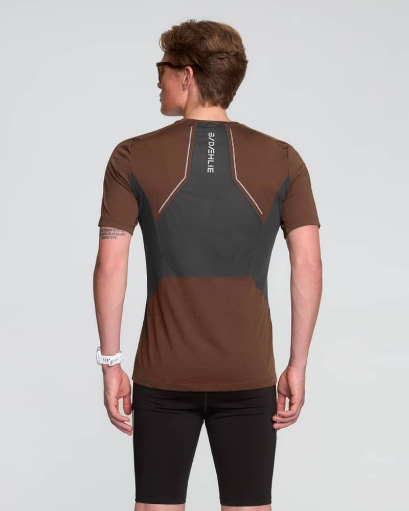 Rear view of a man in the brown Dæhlie T-Shirt Tech Wool, with a reflective logo for running in the dark.