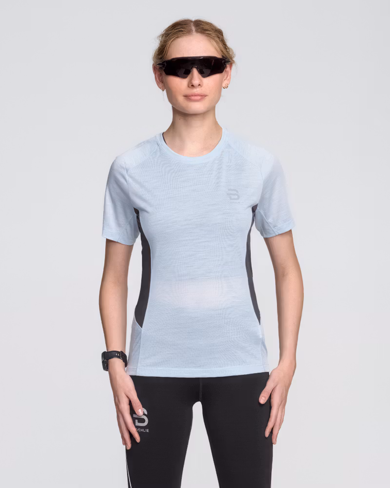 Woman wearing a light blue Dæhlie T-Shirt Tech Wool, a year-round essential for runners seeking performance.
