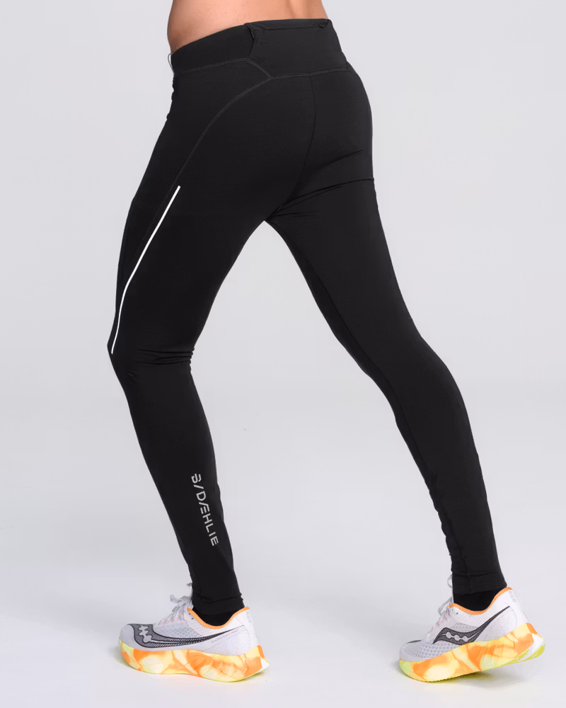 Male runner in Dæhlie's black Tights Tech Wool, showcasing the slim fit and reflective details for visibility during winter.