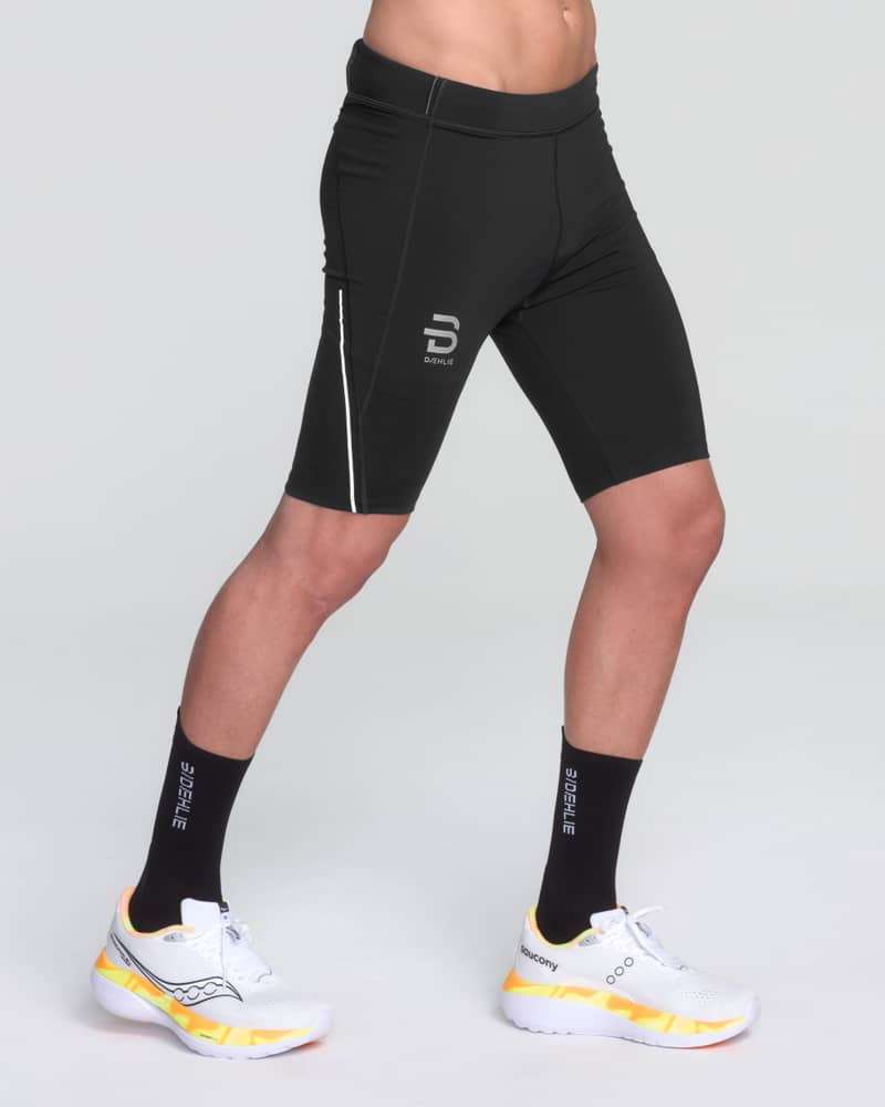 Dæhlie men's 9-inch Tights Tech Wool in black, a short running tights with a reflective logo and breathable fabric.