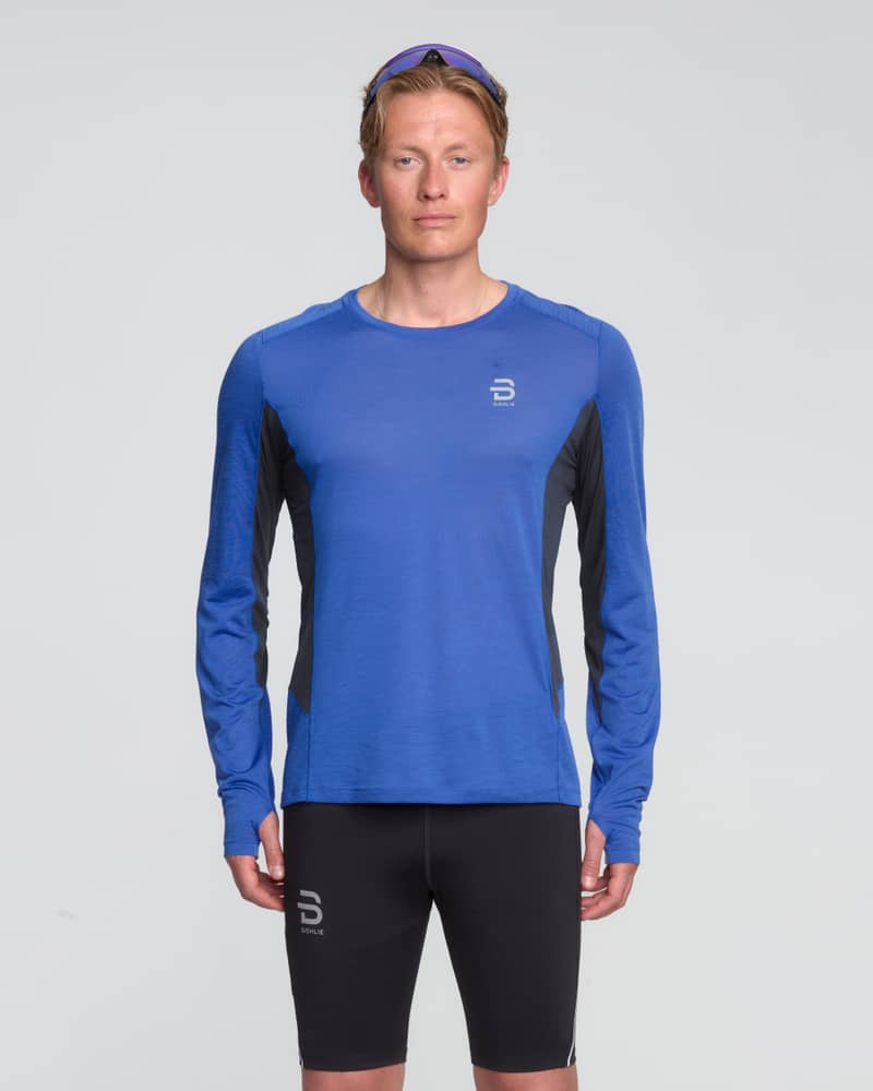 Male runner in a Dæhlie blue Long Sleeve Tech Wool shirt, a base and mid layer with advanced thermoregulation.