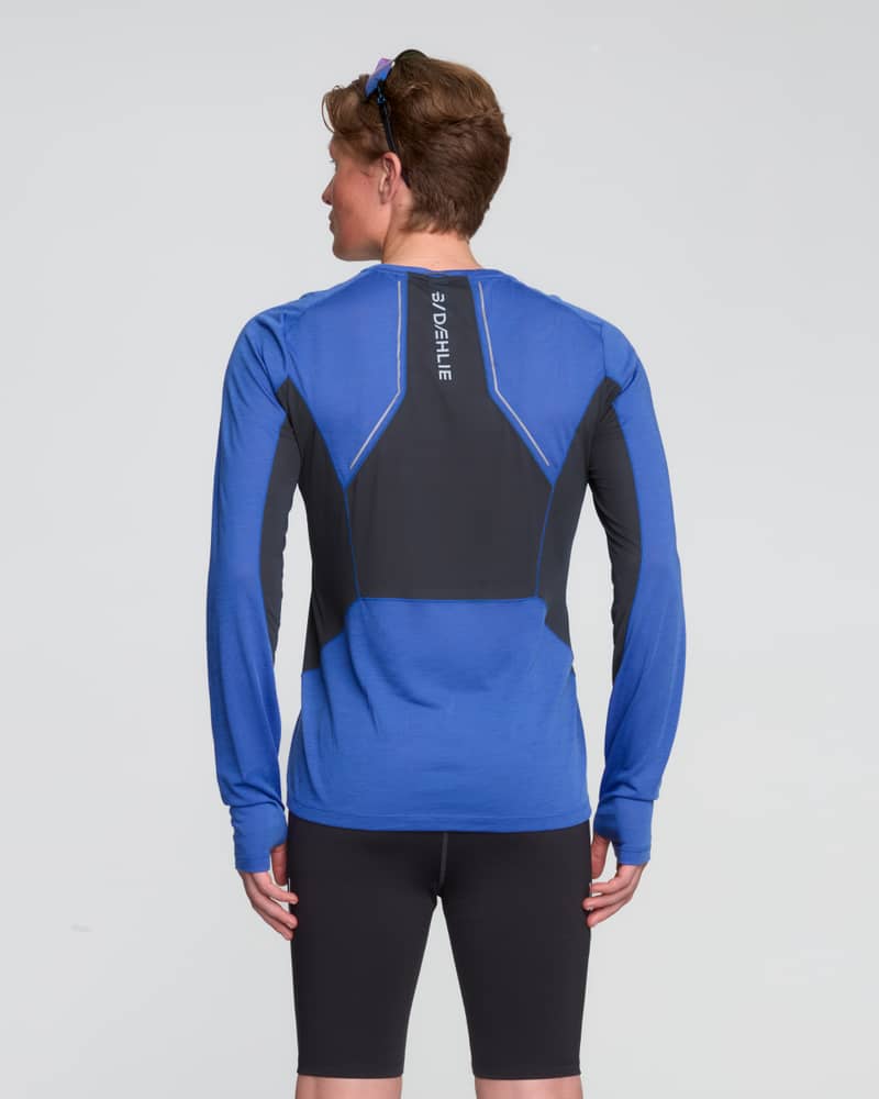 Back view of a man wearing the blue Dæhlie Long Sleeve Tech Wool, with ventilation panels for breathability.