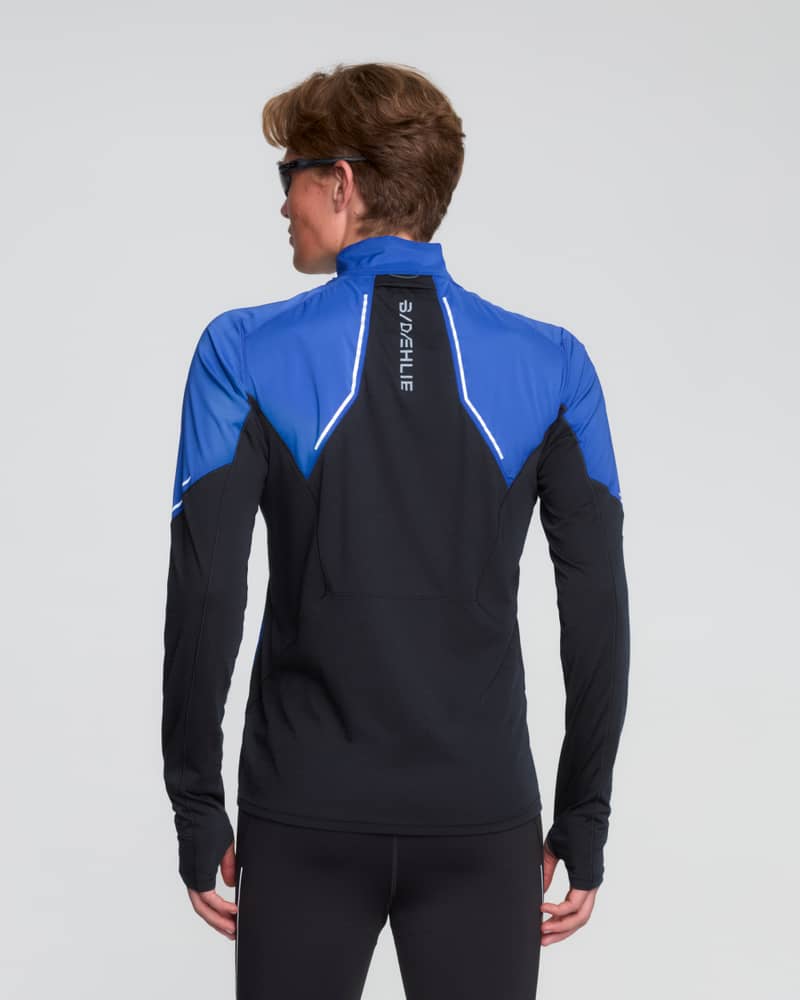 Back view of a runner in a Dæhlie blue tech wool half-zip, showing the reflective details for visibility.