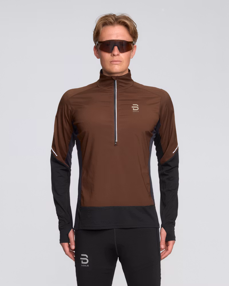Runner in a brown and black Dæhlie Half Zip Tech Wool, a technical midlayer with 37.5® Technology for thermoregulation.