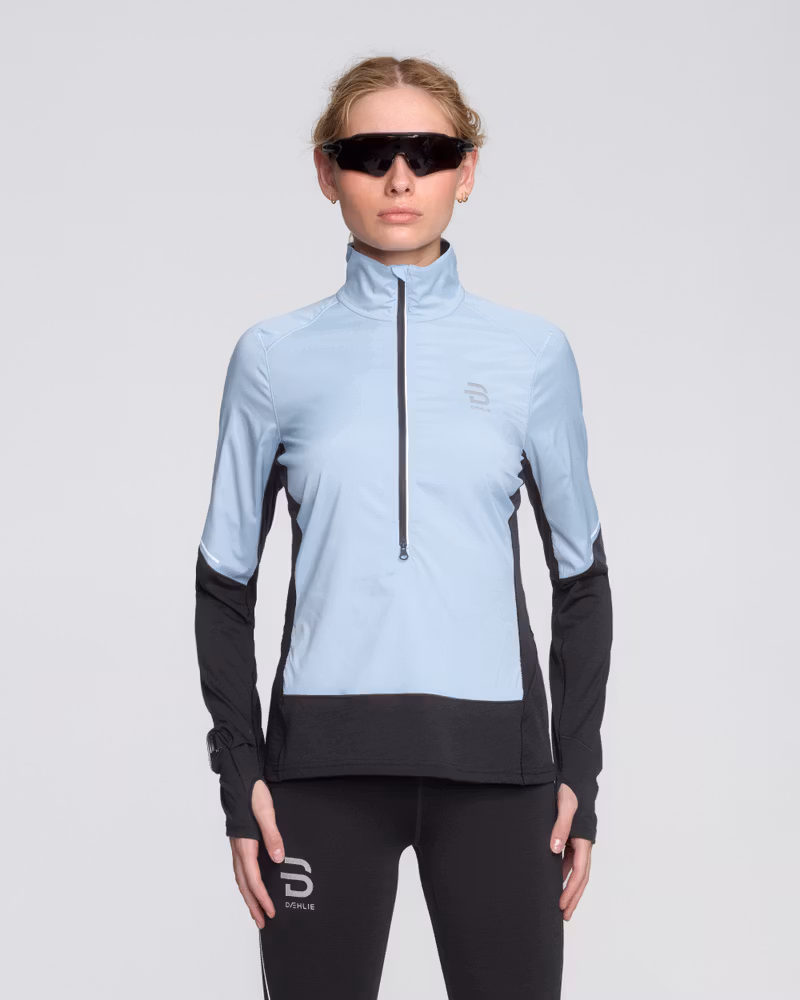 Woman wearing Dæhlie's light blue Half Zip Tech Wool midlayer designed for year-round training and running.