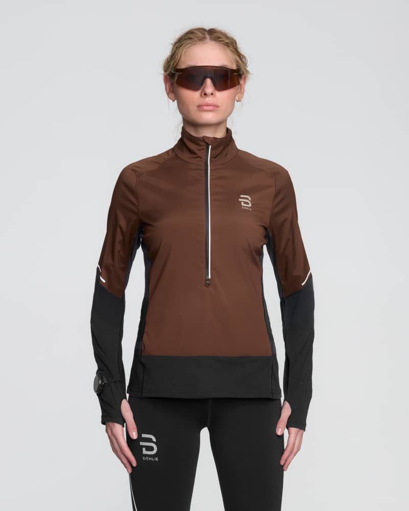 Female runner wearing the brown and black Dæhlie Half Zip Tech Wool, a warm and breathable performance midlayer.