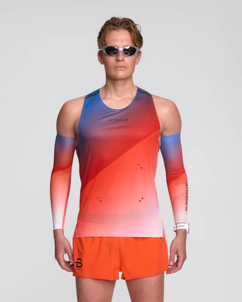 Male runner wearing the Dæhlie Elite Air singlet in a colorful gradient, designed for high-speed racing.
