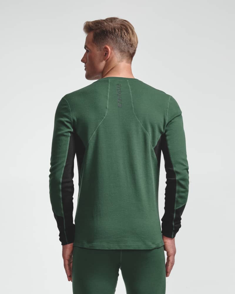Dæhlie male model wearing green baselayer top with black side panels, back view.