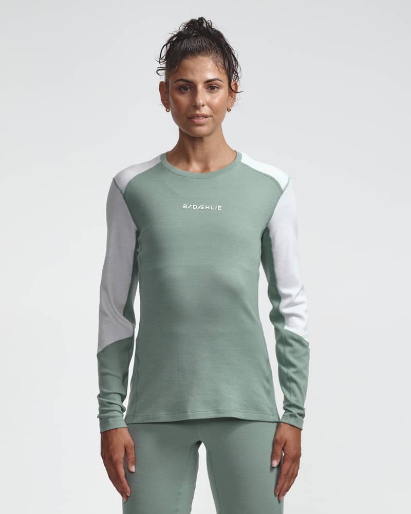 Dæhlie female model wearing green and white baselayer top, front view.