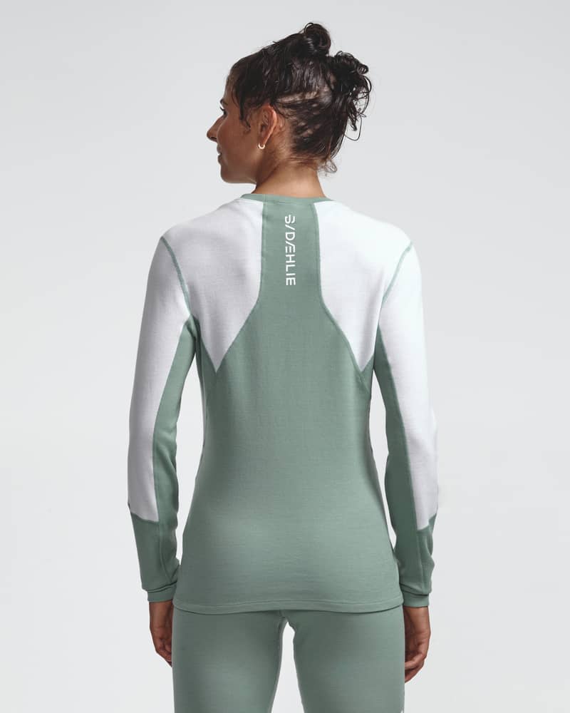 Dæhlie female model wearing green and white baselayer top, back view.